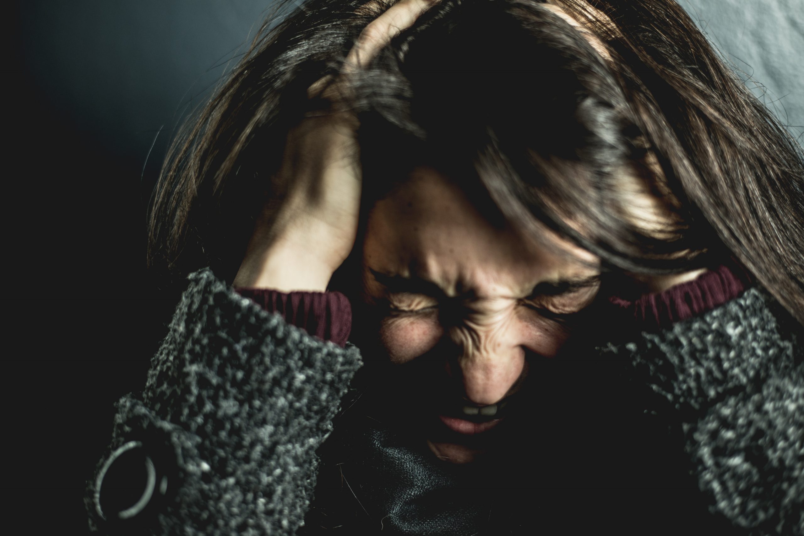 closeup of woman clutching her hair in frustration