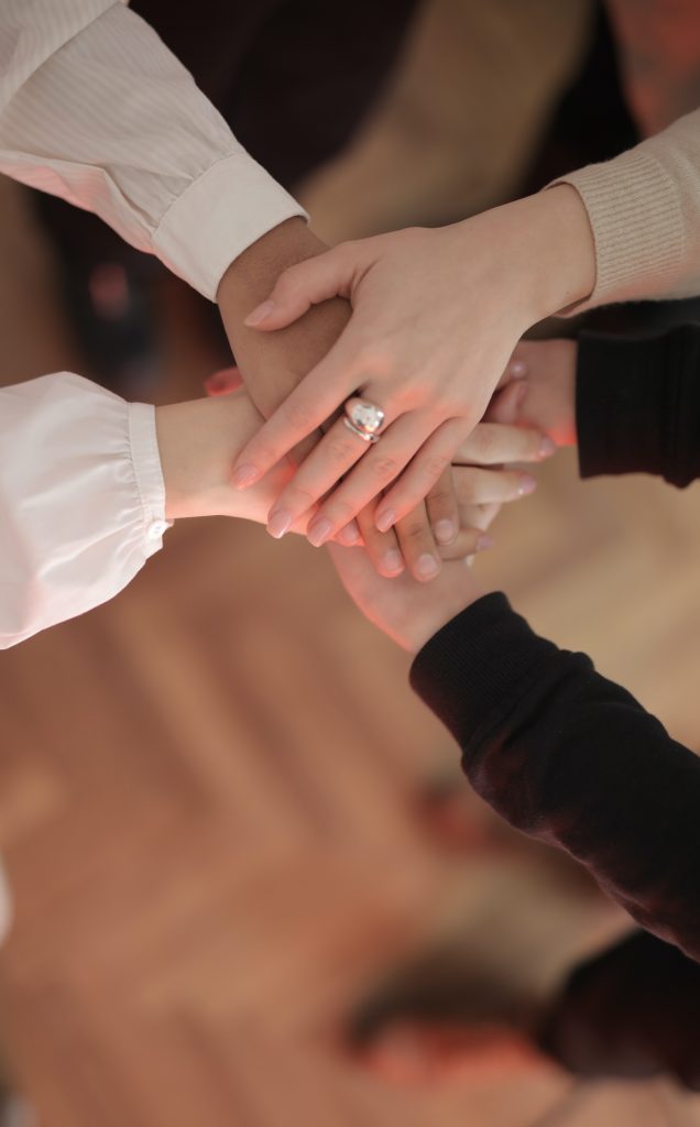 friends stacking hands support group