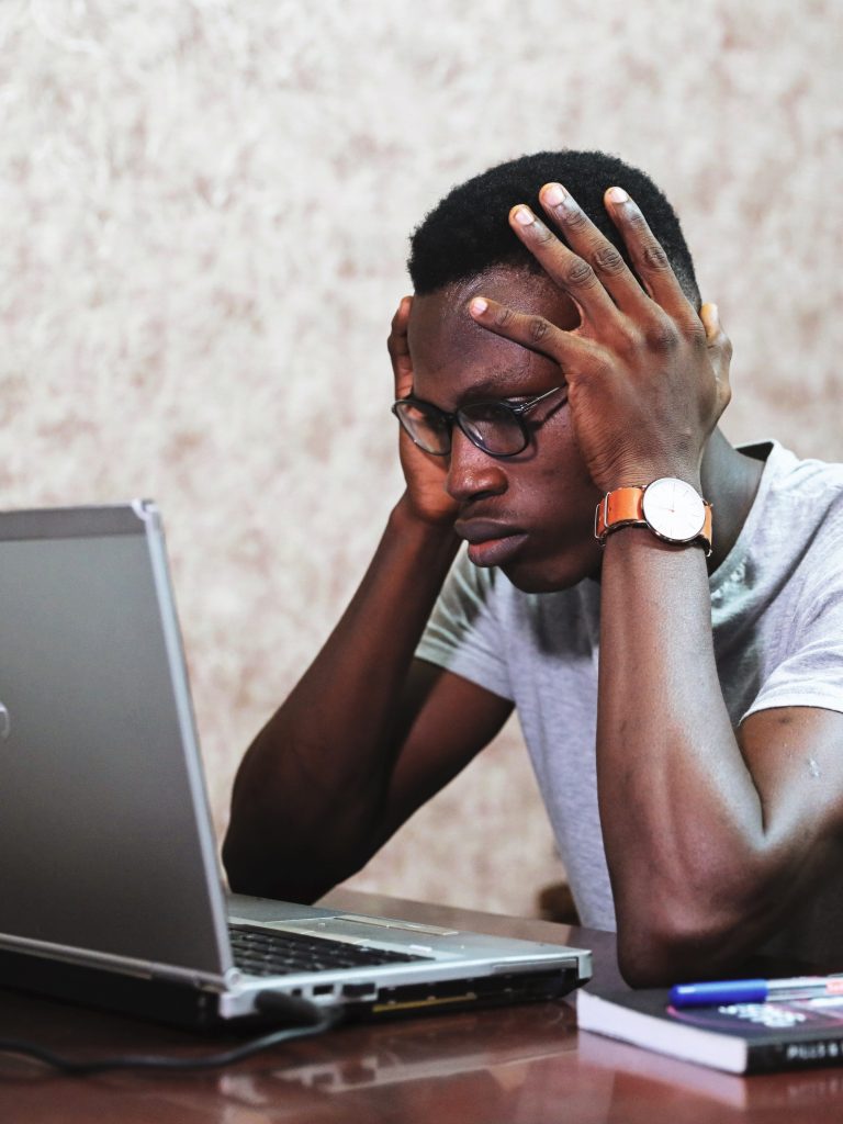 stressed young man sitting at the computer