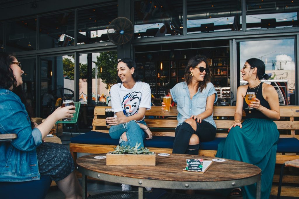 group of people sharing drinks at outdoor cafe