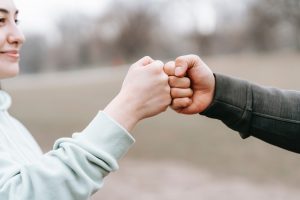 two people fist bumping and smiling