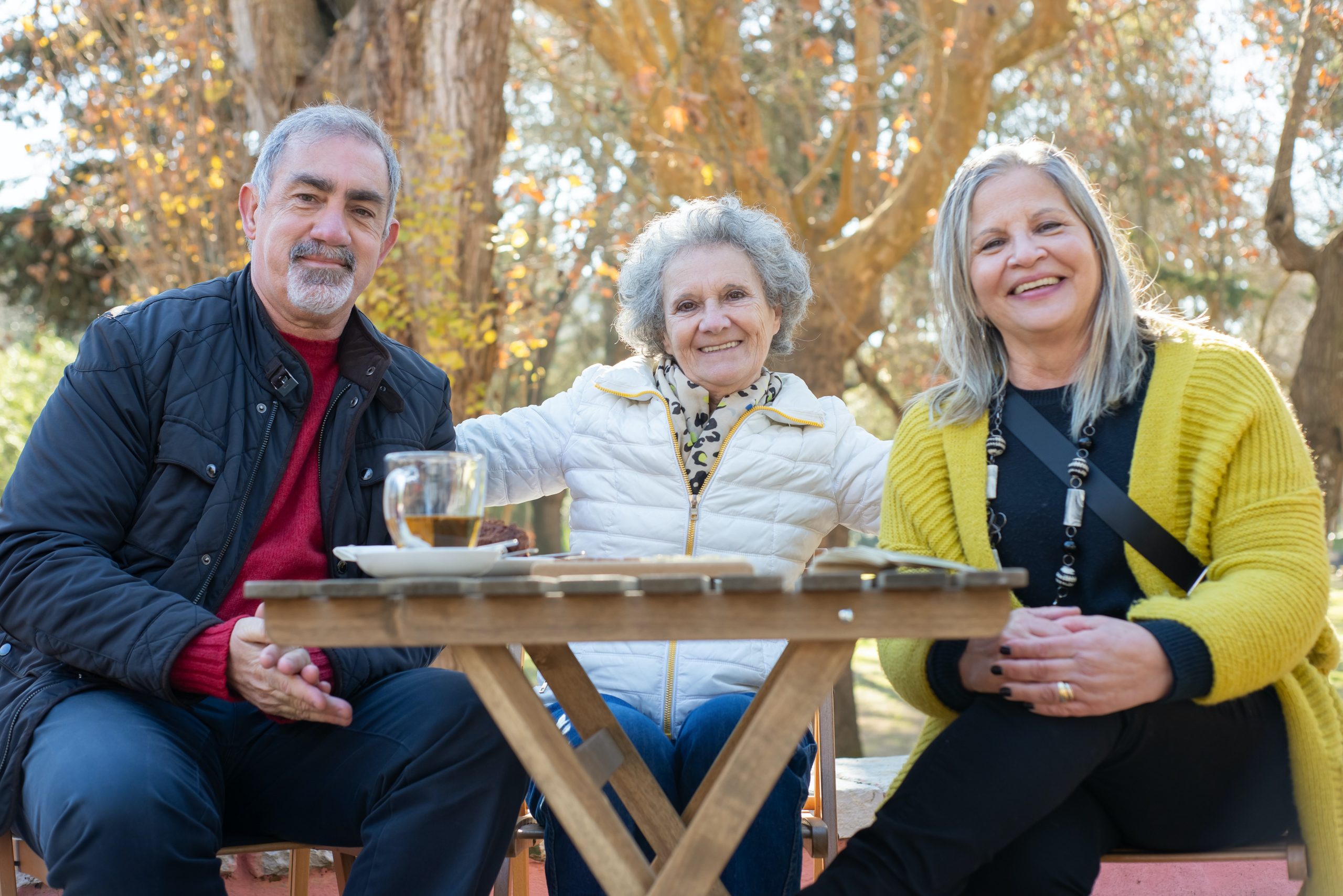 three retirement aged friends socializing at a table