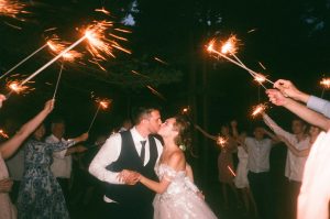 group of people holding sparklers at a wedding party