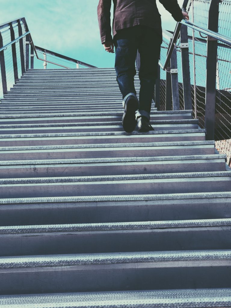 low shot of two feet climbing a flight of stairs