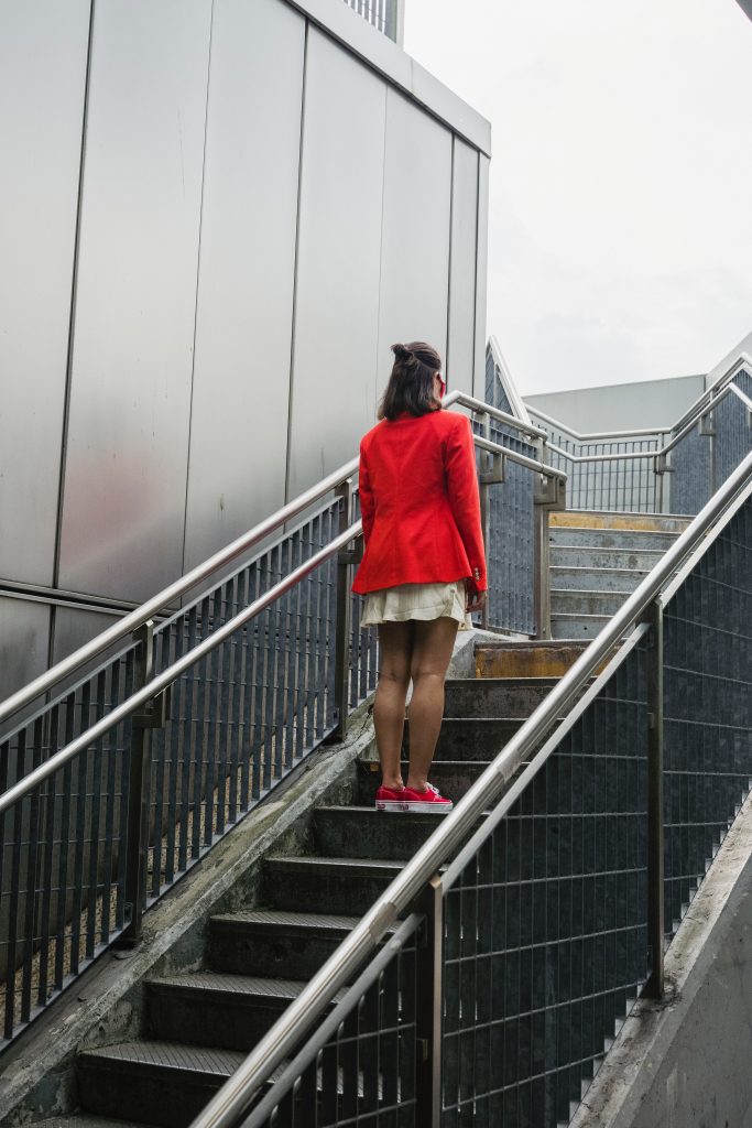 woman in red coat standing on outdoor steps