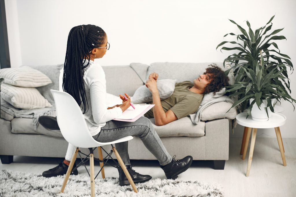 man lying on couch talkiing to therapist