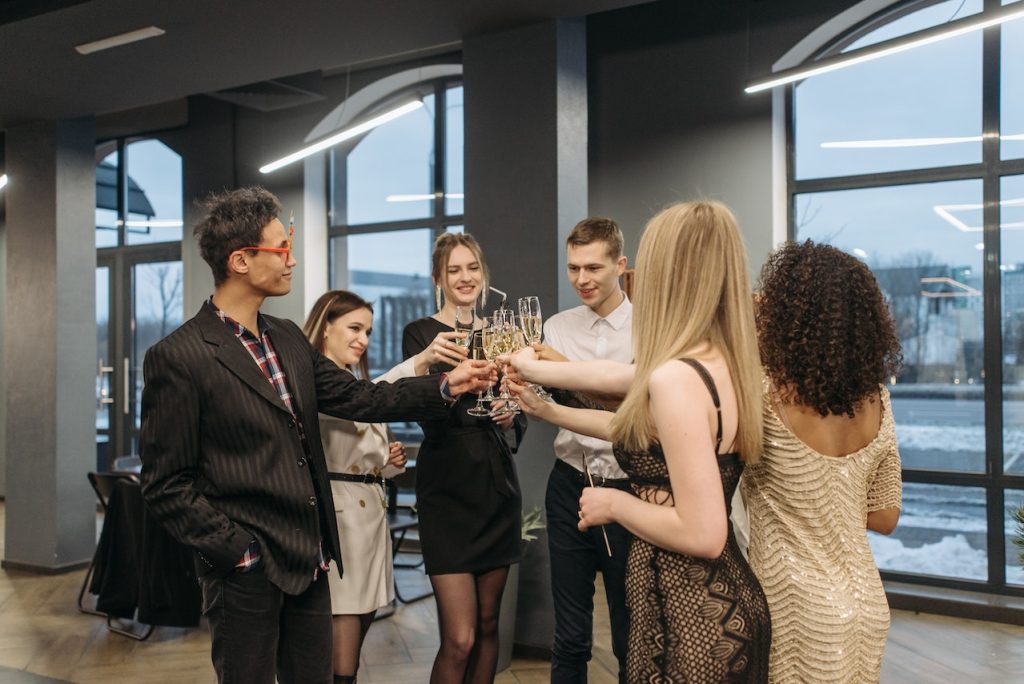 well-dressed coworkers raising glasses at holiday party