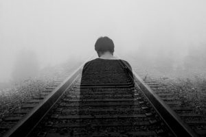transparent image of man standing over railroad tracks