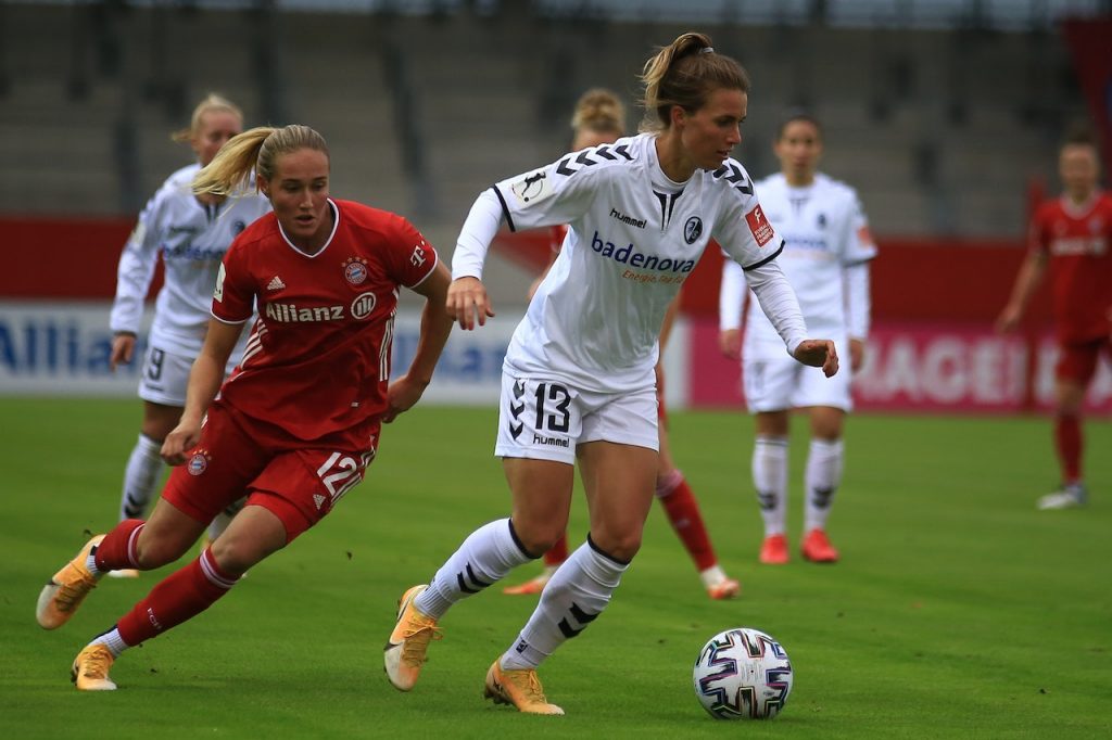 soccer players competing on stadium field