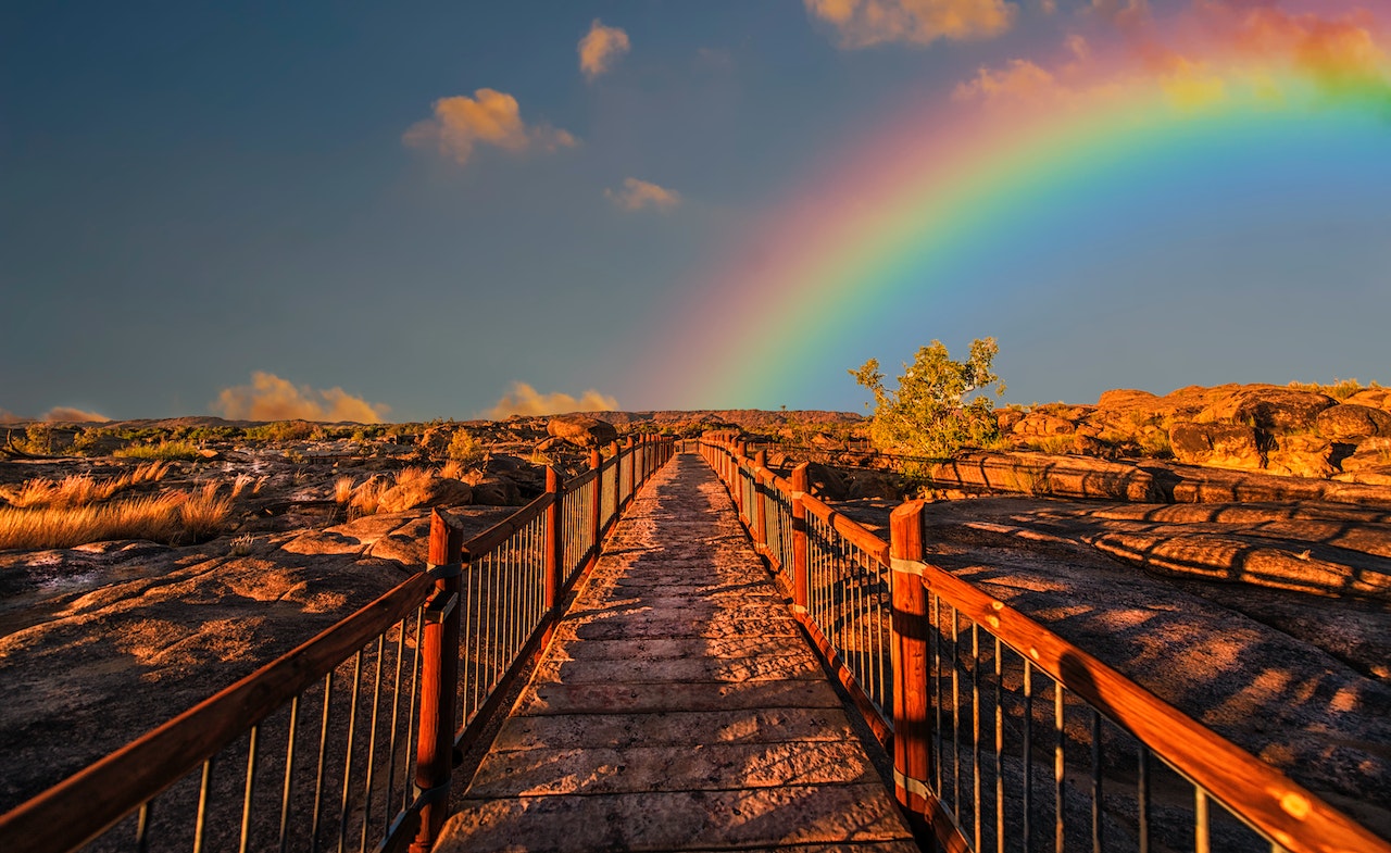 rainbow at end of long desert pathway