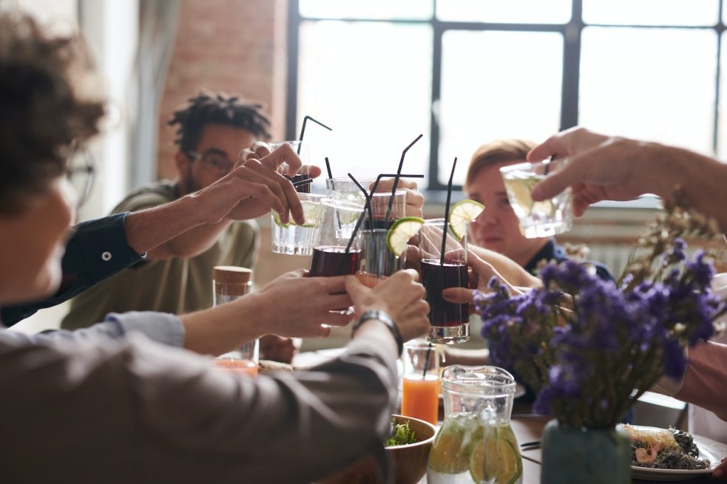 friends raising glasses over lunch table