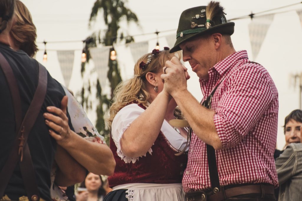 two people dancing together at oktoberfest celebration