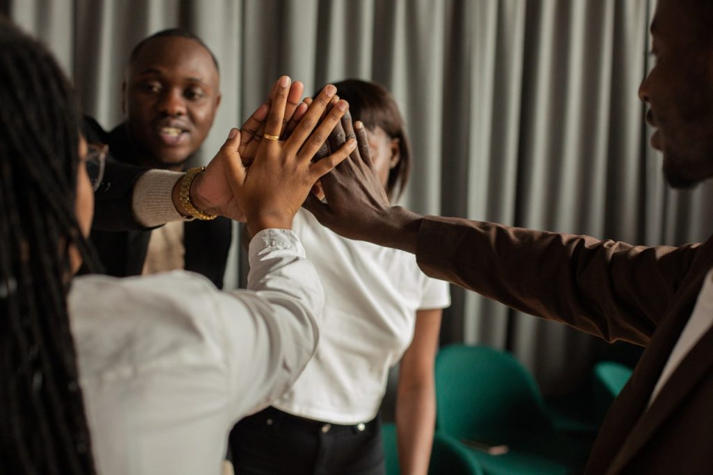 group of people putting hands together solidarity