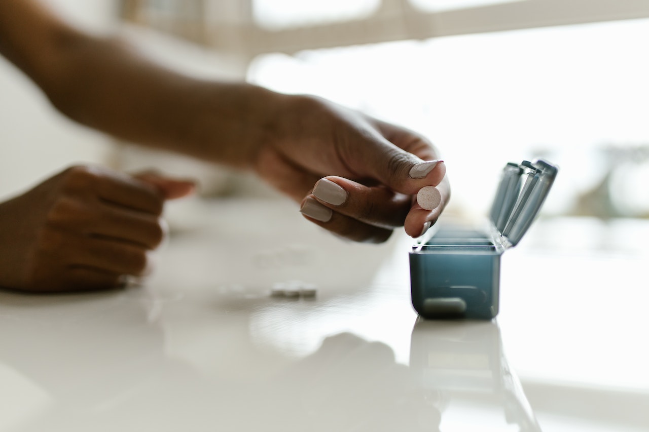 hand organizing prescriptions on counter