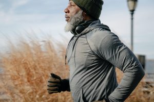 Man with grey beard jogging on clear day