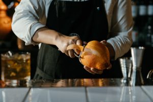 bartender hands cutting orange rind