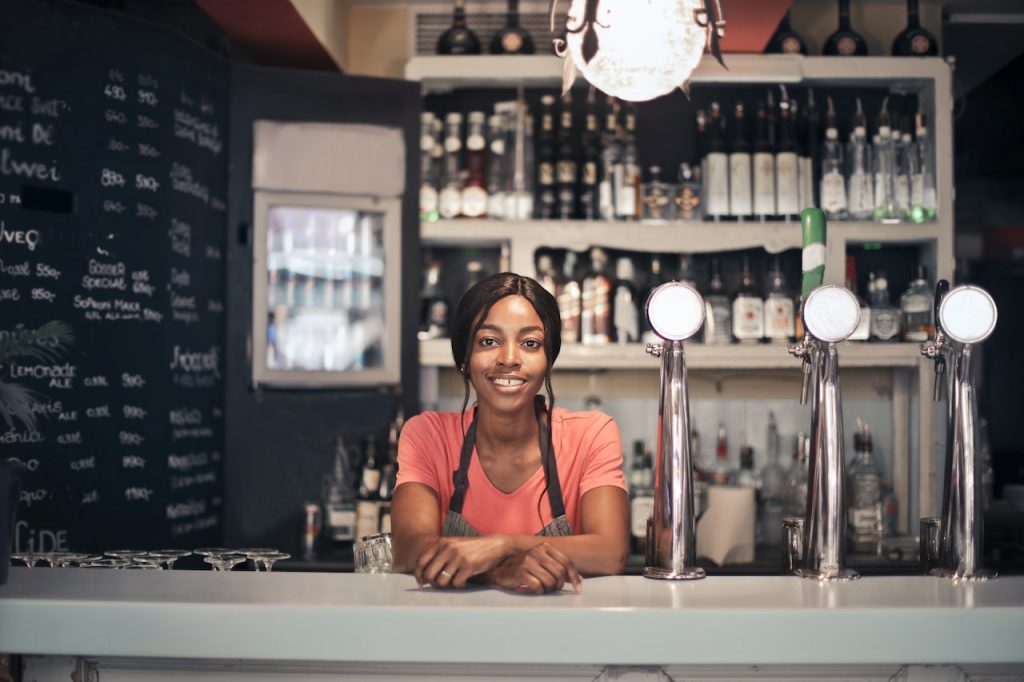 woman standing behind bar and smiling