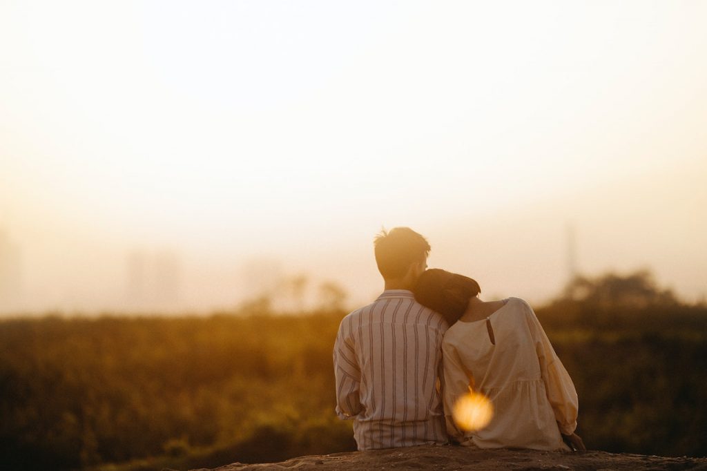 couple leaning on each others shoulders at sunset