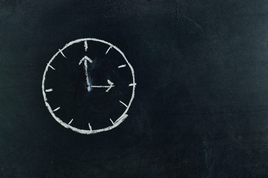 chalk drawing of a clock on a blackboard