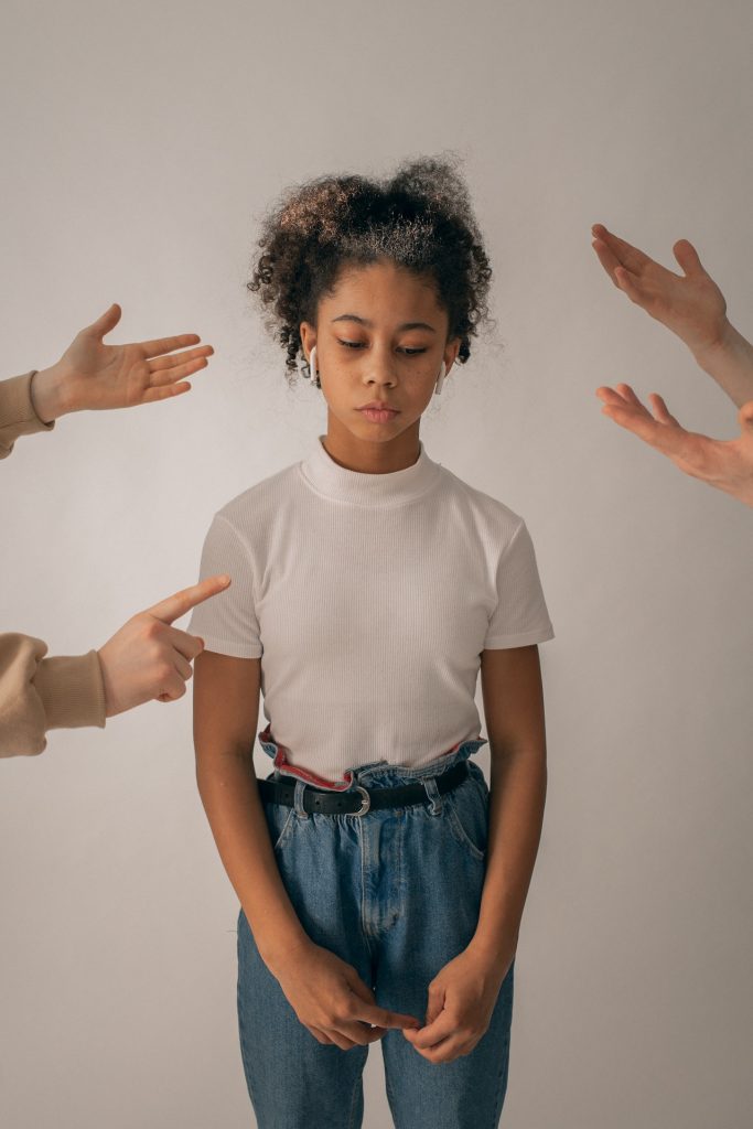 unrecognizable people punishing sad looking child