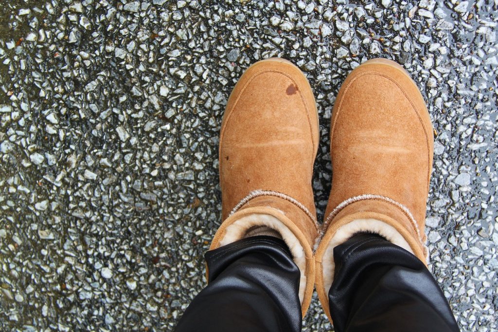 two feet in brown suede snow boots