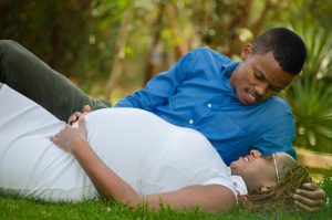 loving pregnant couple lying on grass