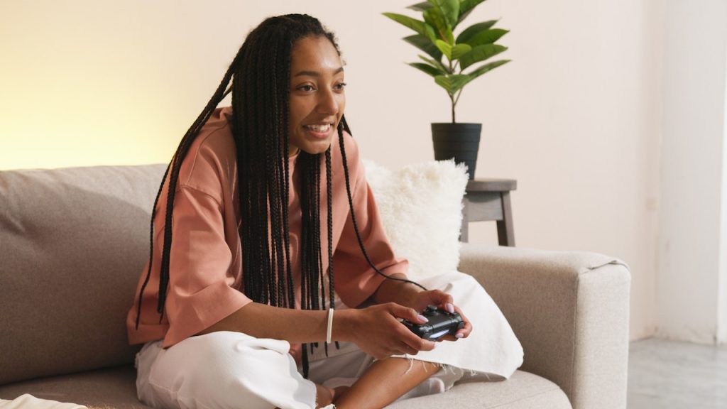 woman playing video games on couch