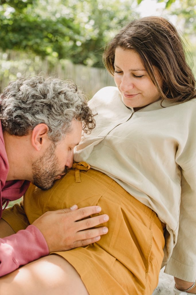 man kissing stomach of expecting partner