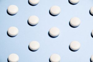 pattern of circular white pills on a light blue background