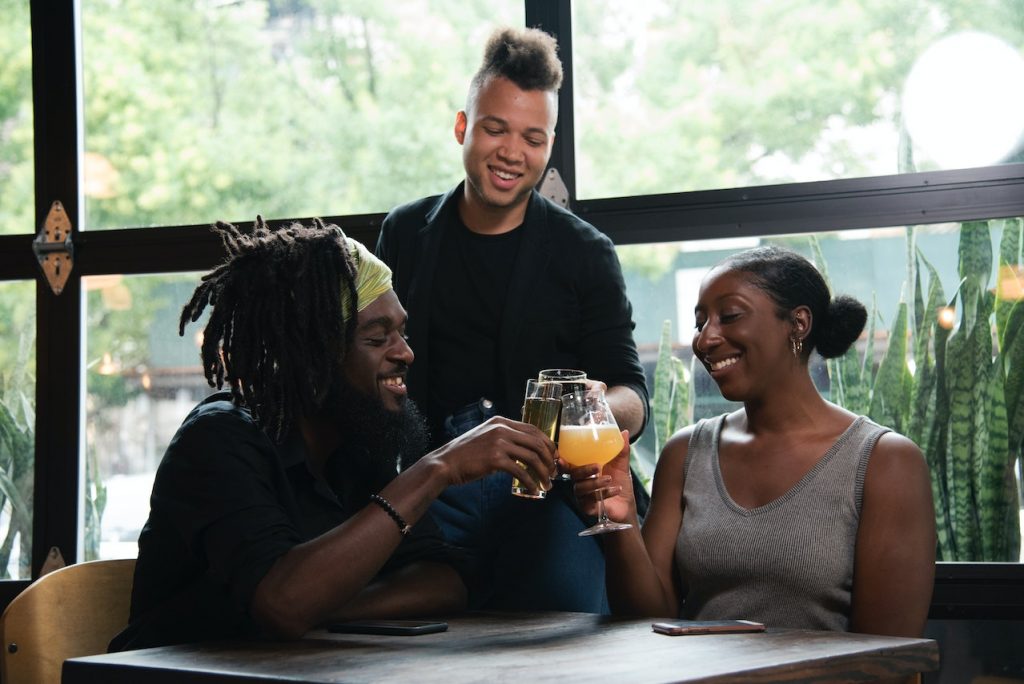 friends clinking beer glasses at table