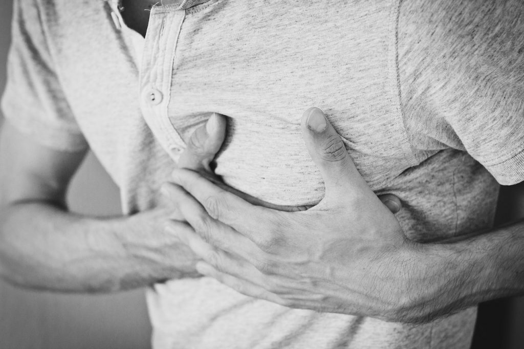 black and white photo of man clutching his chest