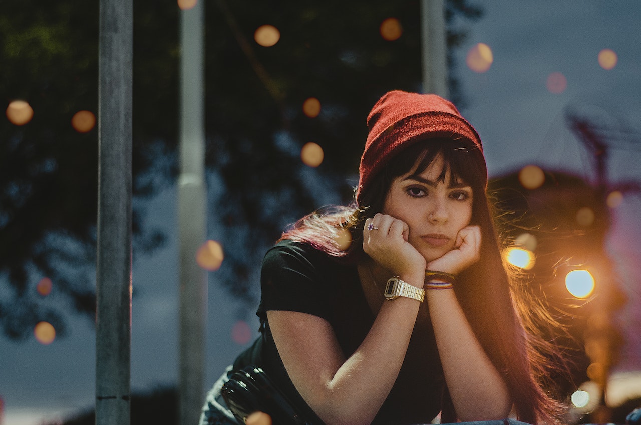 sad-looking woman in black shirt looking into the distance