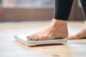 one foot on a scale to check weight loss