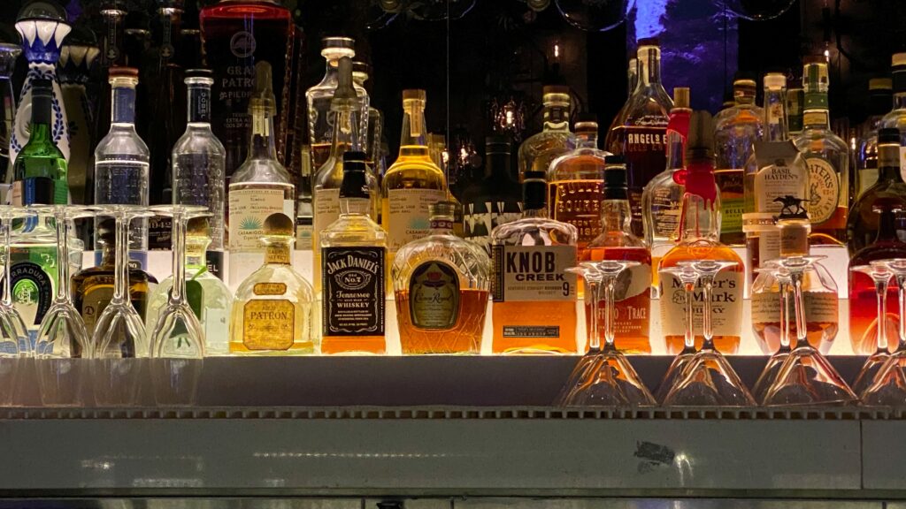Multiple types of bottles of alcohol set up on a bar